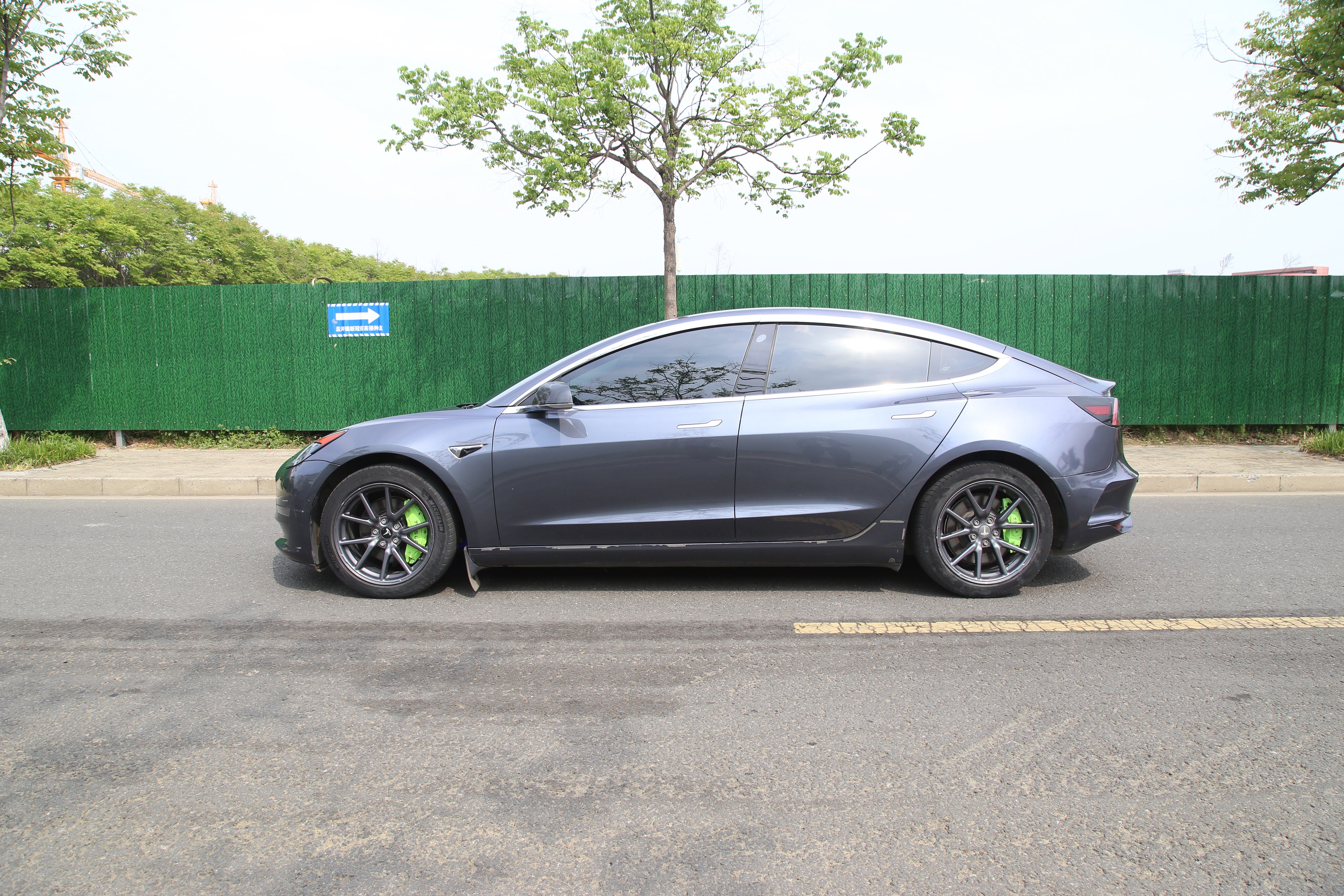 Colored caliper covers installed behind a Tesla Model 3 wheel