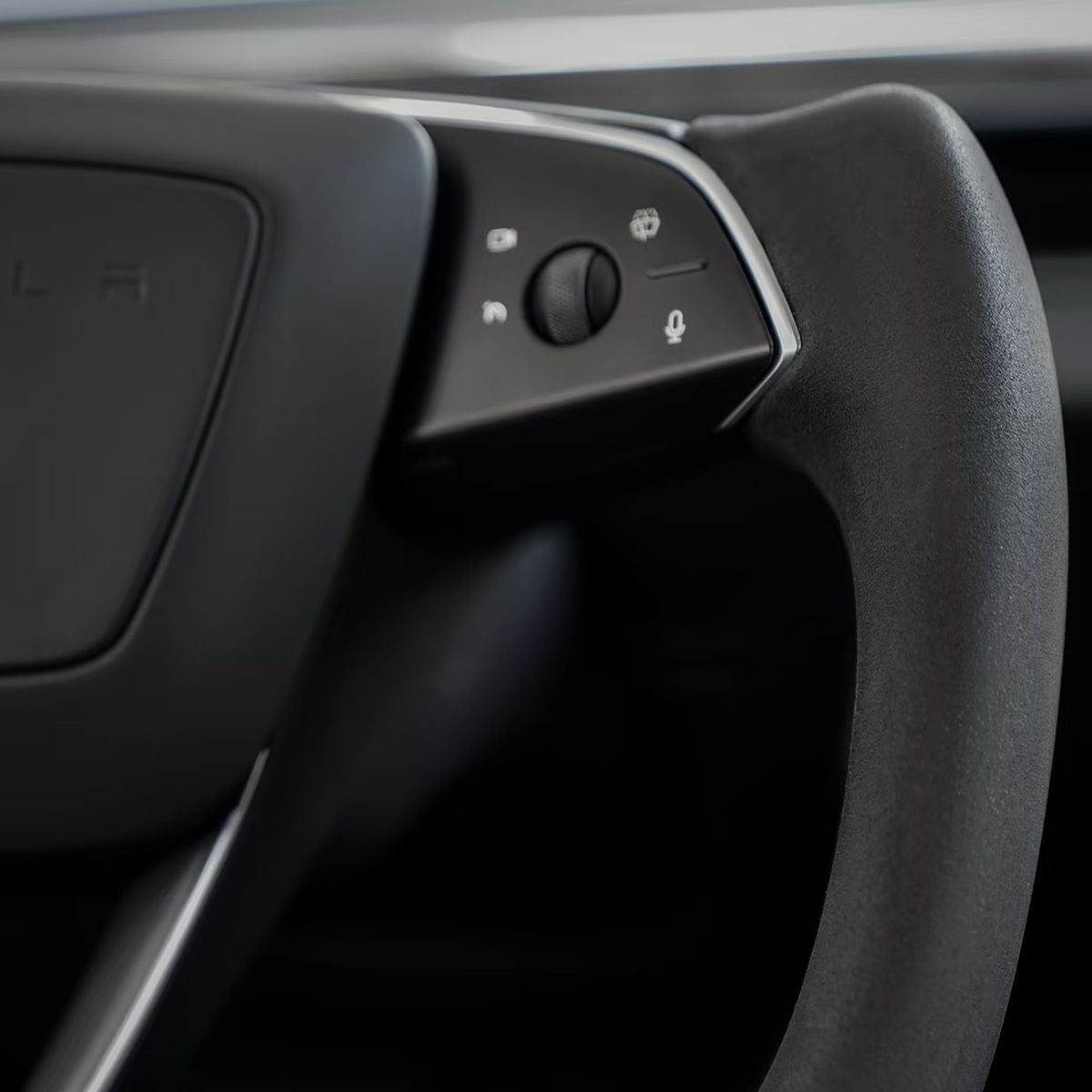 Alcantara texture and stitching detail on a Tesla yoke steering wheel