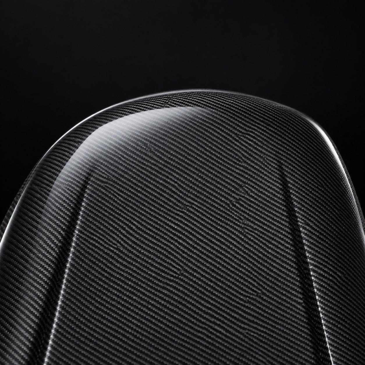 Close-up of the curved carbon fiber panel surface and woven texture.